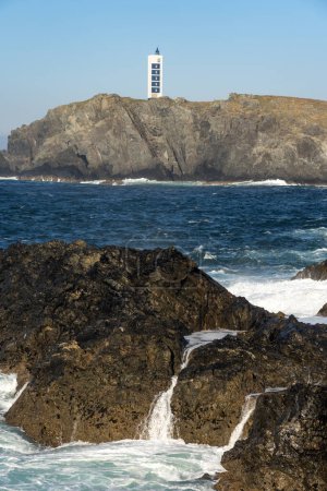 Punta Frouxeira lighthouse with the cliffs in the Rias Altas touristic area of Galicia at sunset, Valdovino, Meiras, Spain.