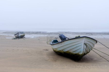 Fishing boats in the Villaviciosa estuary in a foggy day. Asturias, Spain.