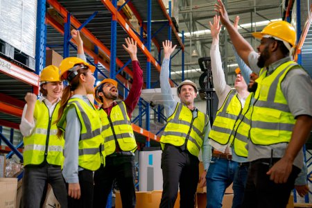Photo for Multi-ethnic warehouse workers raise hands up to show action of very happy from the successful of their project and celebrate together. - Royalty Free Image