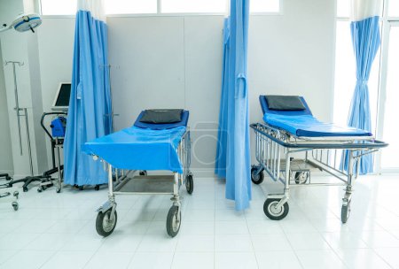Téléchargez les photos : Vide de la salle d'urgence avec deux lits mobiles à l'hôpital pour soutenir et traiter le patient. - en image libre de droit