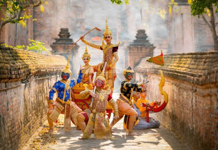 Gruppe von Khon oder traditionelle thailändische Klassiker maskiert von den Ramakien Zeichen stehen zusammen mit Aktion des traditionellen Tanzes mit alten thailändischen Gebäude im Hintergrund des öffentlichen Platzes.