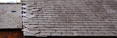 Photo for Loose, slates caused by storm damage on a house roof - Royalty Free Image