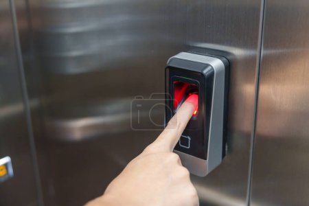 Frau benutzt Fingerabdruck-Scanner in Fahrstuhl Sicherheitssystem im Büro- und Wohnungskonzept