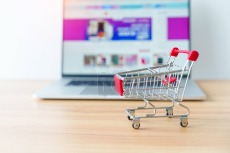 Photo for Shopping cart and laptop computer with marketplace website. business, technology, ecommerce, digital banking and online payment concept - Royalty Free Image