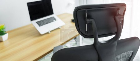 Ergonomischer Stuhl und verstellbarer Tisch mit Laptop am modernen Arbeitsplatz. Gute Haltung zur Vermeidung von Office-Syndrom, Rückenschmerzen, Schulterschmerzen, Fibromyalgie und Nackenschmerzen
