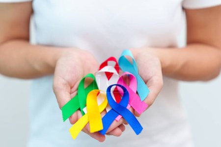 Téléchargez les photos : Journée mondiale du cancer, le 4 février. Rubans bleu, rouge, vert, blanc, rose, bleu marine et jaune pour soutenir les personnes vivant et malades. Concept de journée de sensibilisation aux soins de santé et à l'autisme - en image libre de droit