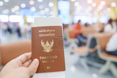 Photo for Hand holding Thailand passport and boarding pass ticket in International airport. Travel, vacation and transportation concepts - Royalty Free Image