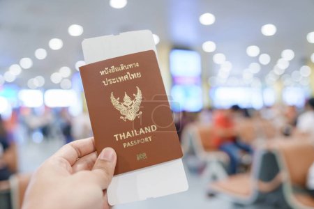 Photo for Hand holding Thailand passport and boarding pass ticket in International airport. Travel, vacation and transportation concepts - Royalty Free Image
