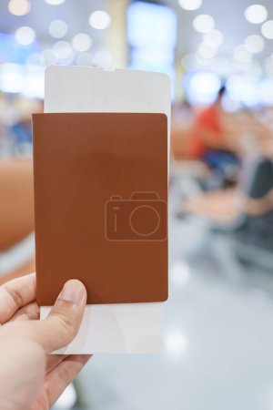 Photo for Hand holding passport and boarding pass ticket in International Airport. Travel, vacation and transportation concepts - Royalty Free Image