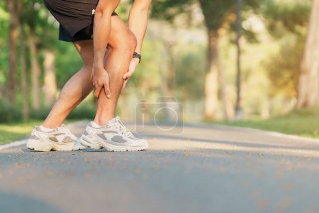 Junger erwachsener Mann mit Muskelschmerzen beim Laufen. Läufermann mit Beinschmerzen wegen Wadenmuskelzerrung. Sportverletzungen und medizinisches Konzept