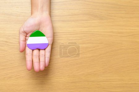 Téléchargez les photos : Queer Pride Day et LGBT pride month concept. main tenant pourpre, blanc et vert forme de coeur pour lesbiens, gais, bisexuels, transgenres, genderqueer et ansexuels communauté - en image libre de droit