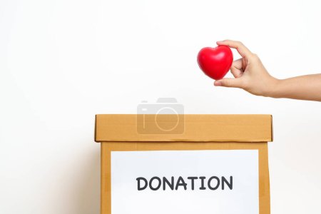 Téléchargez les photos : Don d'organes, charité, bénévolat, don et concept de sang. Main tenant le cœur rouge dans une boîte de dons pour soutenir les pauvres, les sans-abri, la responsabilité sociale de la RSE, la Journée mondiale de la santé mentale et cardiaque - en image libre de droit