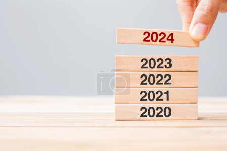 Foto de 2024 block over 2023 and 2022 wooden building on table background. Business planning, Risk Management, Resolution, strategy, solution, goal, New Year New You and happy holiday concepts - Imagen libre de derechos