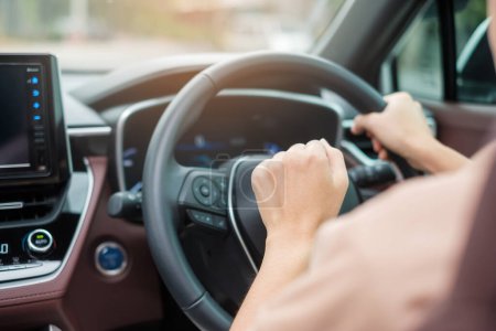 Photo for Woman driver honking a car during driving on traffic road, hand controlling steering wheel in vehicle. Journey, trip and safety Transportation concepts - Royalty Free Image