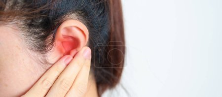 Femme tenant son oreille douloureuse. Maladie de l'oreille, atrésie, otite moyenne, gonflement, tympan perforé, syndrome de Meniere, otolaryngologue, Vieillissement de l'ouïe et concept de santé