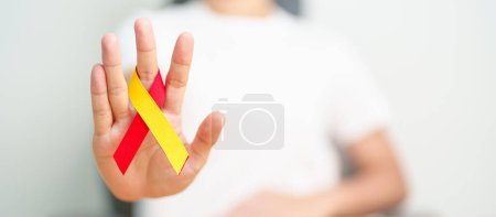 Photo for Woman holding Red and Yellow ribbon. World hepatitis day awareness month, 28 July, Liver cancer, Jaundice, Cirrhosis, Failure, Enlarged, Hepatic Encephalopathy and Health concept - Royalty Free Image