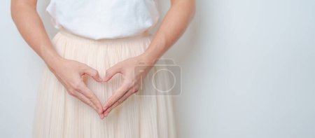 Photo for Woman hand heart shape over abdomen. Ovarian and Cervical cancer, Endometriosis, Hysterectomy, Uterine fibroids, Reproductive, menstruation, Stomach, Pregnancy and Sexual Transmitted disease concept - Royalty Free Image