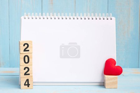Photo for Blank notebook and 2024 cubes with red heart shape decoration on blue wooden table background. New Year NewYou, Goal, Resolution, health, Love - Royalty Free Image