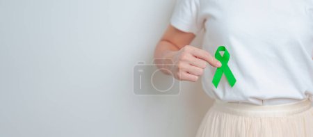 Photo for Woman having liver pain with green ribbon. Liver Cancer October awareness month, Tumor, Jaundice, Virus Hepatitis, Cirrhosis, Failure, Enlarged, Hepatic Encephalopathy, and health concept - Royalty Free Image