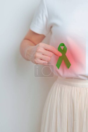 Photo for Woman having liver pain with green ribbon. Liver Cancer October awareness month, Tumor, Jaundice, Virus Hepatitis, Cirrhosis, Failure, Enlarged, Hepatic Encephalopathy, and health concept - Royalty Free Image