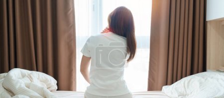 Foto de Mujer que tiene dolor de cuello y hombro durante sentarse en la cama en casa. Dolor muscular por síndrome de dolor miofascial y fibromialgia, reumatismo, dolor escapular, columna cervical. Concepto Despertar y Salud - Imagen libre de derechos