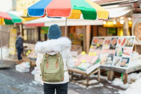 Photo for Woman tourist Visiting in Hakodate, Traveler in Sweater sightseeing Asaichi Morning Market Hakodate in winter. landmark and popular for attractions in Hokkaido, Japan. Travel and Vacation concept - Royalty Free Image