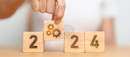Photo for 2024 block with gear icon. Business Process, Team, teamwork, Goal, Target, Resolution, strategy, plan, Action, motivation, change, brainstorm and New Year start concepts - Royalty Free Image