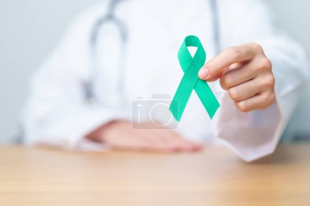Photo for Doctor holding Teal Ribbon for January Cervical Cancer Awareness month. Uterus and Ovaries, Cervix, Endometriosis, Hysterectomy, Uterine fibroids, Reproductive, Healthcare and World cancer day - Royalty Free Image