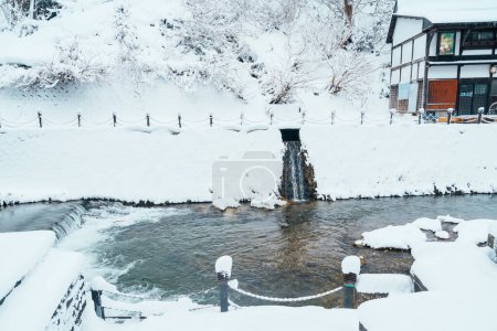 Photo for Foot bath hot spring in Ginzan Onsen with snow fall in winter season is most famous Japanese Hot Spring in Yamagata, Japan. - Royalty Free Image