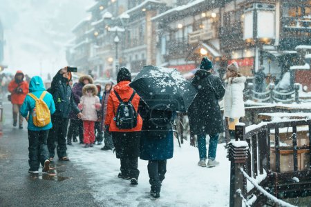 Téléchargez les photos : Touriste à Ginzan Onsen avec chute de neige en saison d'hiver est la source chaude japonaise la plus célèbre à Yamagata, Japon. - en image libre de droit
