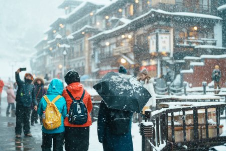 Photo for Tourist in Ginzan Onsen with snow fall in winter season is most famous Japanese Hot Spring in Yamagata, Japan. - Royalty Free Image