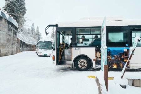 Téléchargez les photos : Arrêt de bus à Ginzan Onsen pour la gare d'Oishida avec chute de neige en saison hivernale est la plus célèbre source chaude japonaise à Yamagata, Japon. Yamagata, Japon, 24 janvier 2024 - en image libre de droit