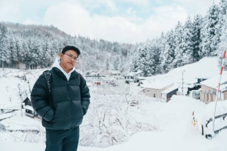 Téléchargez les photos : Homme touriste Visiter Ginzan Onsen à Yamagata, heureux voyageur visiter le village japonais Onsen avec neige en saison hivernale. repère et populaire pour l'attraction au Japon. Voyage et vacances concept - en image libre de droit