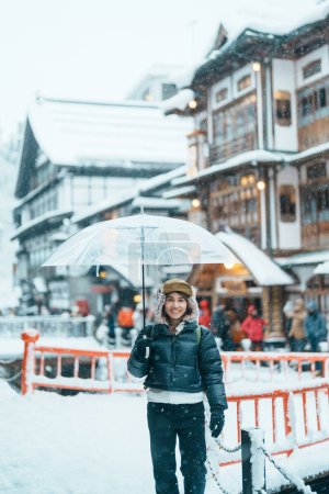 Photo for Woman tourist Visiting Ginzan Onsen in Yamagata, happy Traveler sightseeing Japanese Onsen village with Snow in winter season. landmark and popular for attraction in Japan. Travel and Vacation concept - Royalty Free Image