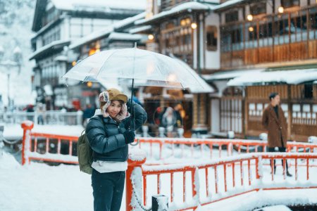 Photo for Woman tourist Visiting Ginzan Onsen in Yamagata, happy Traveler sightseeing Japanese Onsen village with Snow in winter season. landmark and popular for attraction in Japan. Travel and Vacation concept - Royalty Free Image