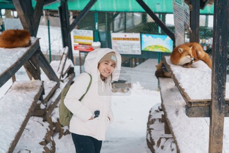 Photo for Woman tourist with Cute fox on snow in winter season at Zao fox village, traveler sightseeing Miyagi prefecture. landmark and popular for attraction near Sendai, Tohoku, Japan. Travel and Vacation - Royalty Free Image