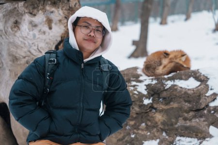 Photo for Man tourist with Cute fox on snow in winter season at Zao fox village, traveler sightseeing Miyagi prefecture. landmark and popular for attraction near Sendai, Tohoku, Japan. Travel and Vacation - Royalty Free Image