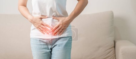 female problem and Endometriosis, Hysterectomy and Menstrual on the sofa at home, woman having abdomen ache due to Stomach pain, digestion with constipation or Diarrhea from food poisoning