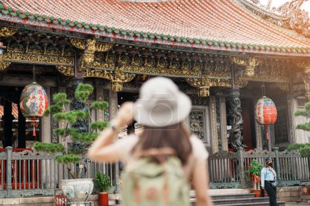 viajera que visita en Taiwán, turista con visita de sombrero en el templo de Longshan, templo religioso popular chino en el distrito de Wanhua, ciudad de Taipei. hito y popular. Concepto de viajes y vacaciones