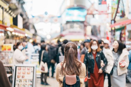 Foto de Mujer turista visita el mercado de Ameyoko, una concurrida calle del mercado ubicada en Ueno. Monumento y popular para la atracción turística y destino de viajes en Tokio, Japón y Asia concepto - Imagen libre de derechos