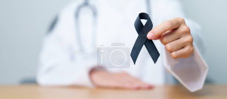 Photo for Melanoma and skin cancer, Vaccine injury awareness month and rest in peace concepts. doctor holding black Ribbon - Royalty Free Image