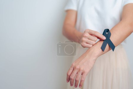 Téléchargez les photos : Mélanome et cancer de la peau, Mois de sensibilisation aux blessures causées par le vaccin et concept de paix. Femme tenant ruban noir - en image libre de droit