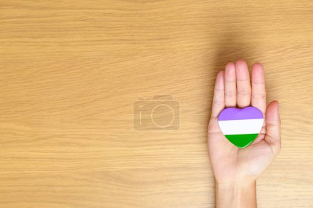 Téléchargez les photos : Queer Pride Day et LGBT pride month concept. main tenant pourpre, blanc et vert forme de coeur pour lesbiens, gais, bisexuels, transgenres, genderqueer et ansexuels communauté - en image libre de droit