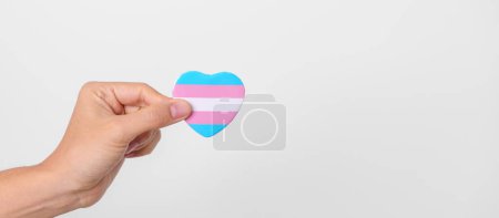 Journée transgenre et mois de la fierté LGBT, concept LGBTQ + ou LGBTQIA +. main tenant la forme de coeur bleu, rose et blanc pour lesbiennes, gais, bisexuels, transgenres, queer et ansexuels communauté
