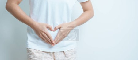 Woman hand heart shape over abdomen. Ovarian and Cervical cancer, Endometriosis, Hysterectomy, Uterine fibroids, Reproductive, menstruation, Stomach, Pregnancy and Sexual Transmitted disease concept