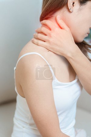 Mujer con dolor de cuello y hombro en casa. Dolor muscular por síndrome de dolor miofascial y fibromialgia, reumatismo, dolor escapular, columna cervical. concepto ergonómico