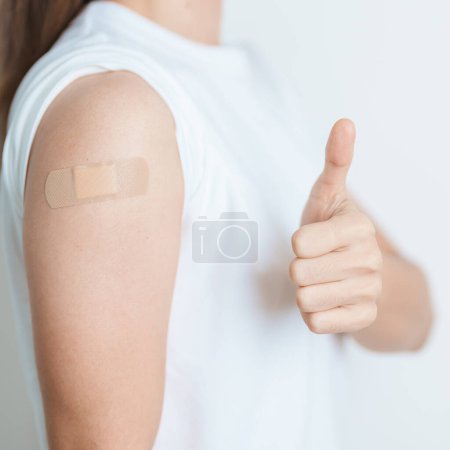 Femme avec bandage après avoir reçu le vaccin. Vaccination et immunisation contre la grippe, le VPH, le zona, la PI, le PVQ ou la diphtérie, le tétanos et la coqueluche, le RRO, l'hépatite B, le vaccin contre la coqueluche et la varicelle