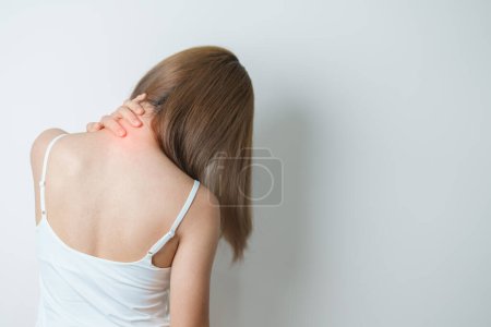 Frau mit Nacken- und Schulterschmerzen zu Hause. Muskelschmerzen aufgrund des Myofaszialen Schmerzsyndroms und der Fibromyalgie, Rheuma, Skapulierschmerzen, Halswirbelsäule. Ergonomisches Konzept