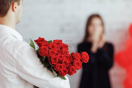 Photo for Man holding gift bouquet of red roses for woman. Celebrating Women's day. Saint Valentine's day. - Royalty Free Image