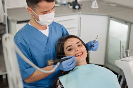 Téléchargez les photos : Image d'un patient souriant regardant la caméra du dentiste. - en image libre de droit